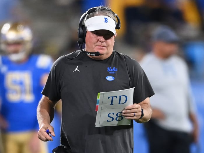 Chip Kelly holds a notebook
